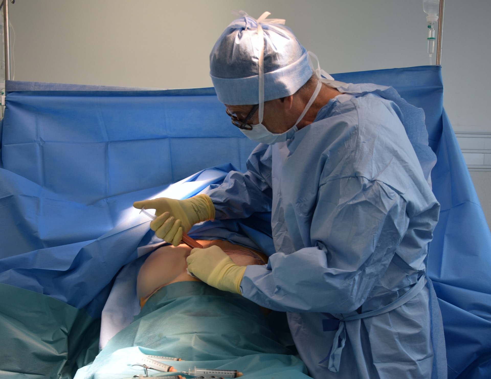 Plastic surgeon injecting to patient's body