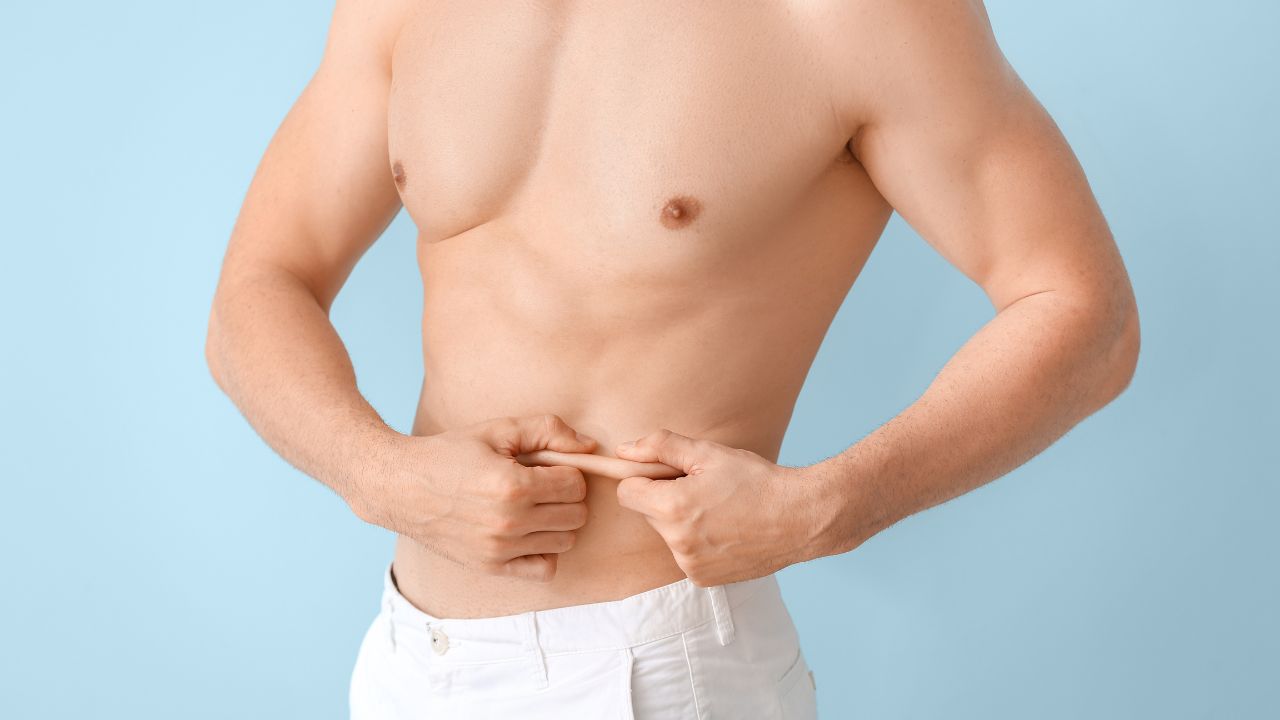 Young man touching his belly fat
